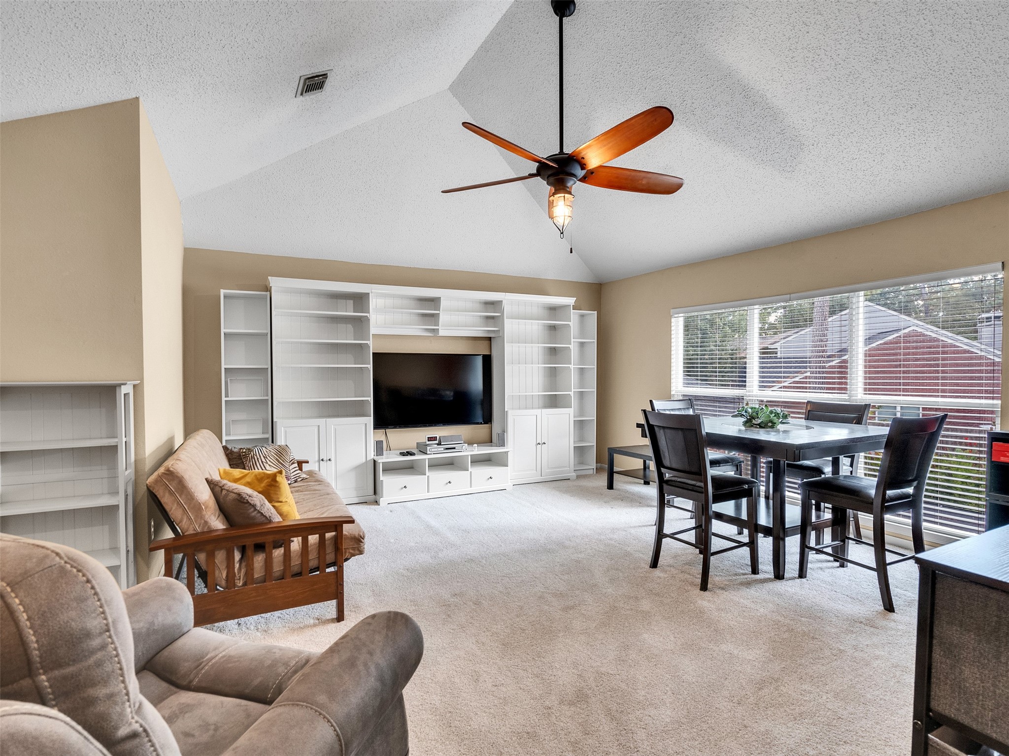 87 South Copper Sage Circle Spring, TX 77381 - Photo 16 of 28 upstairs game room features vaulted ceiling, a ceiling fan, and a large window facing the backyard oasis spilling in tons natural light. The plush carpet was replaced in 2021