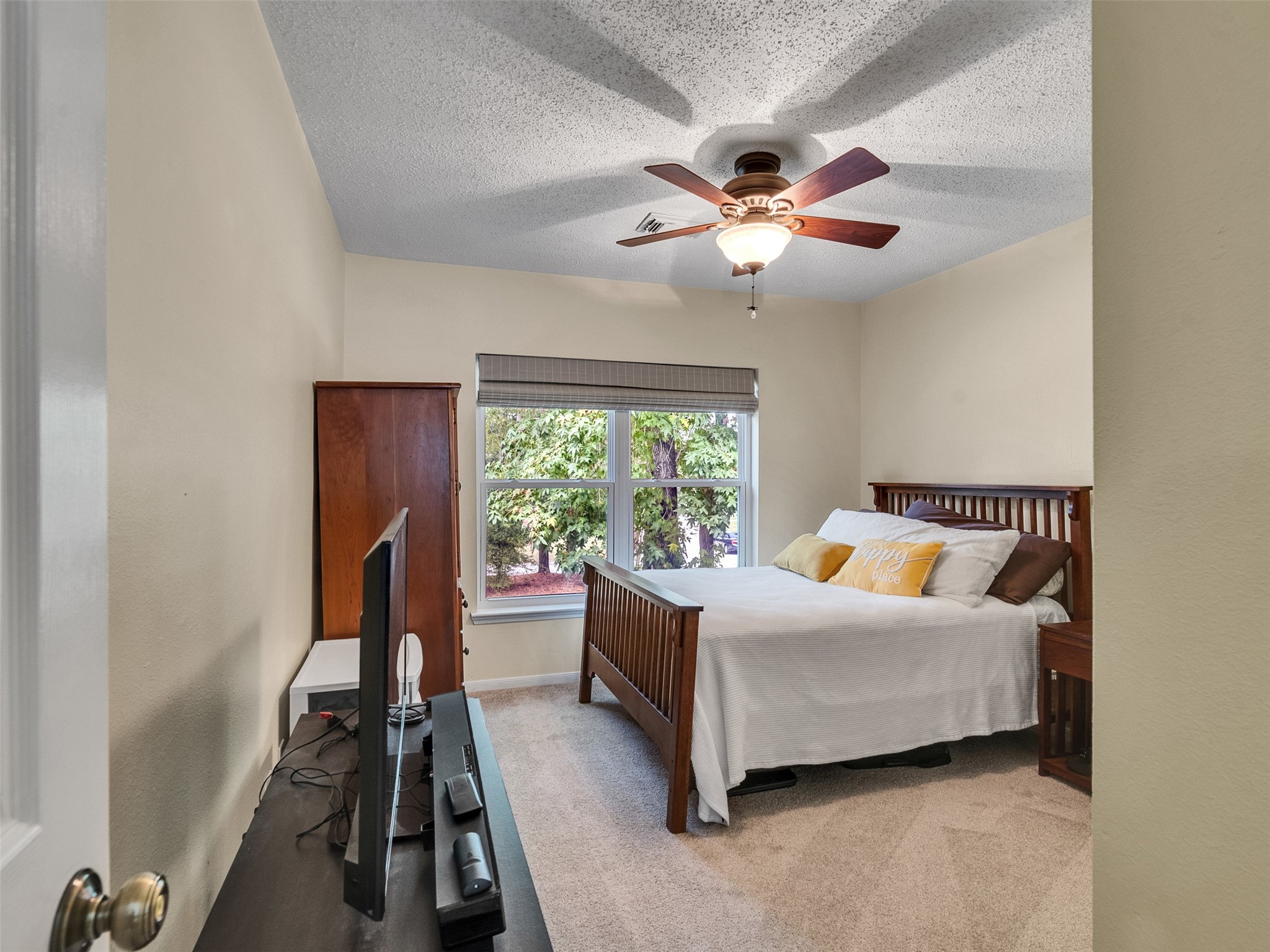 87 South Copper Sage Circle Spring, TX 77381 - Photo 18 of 28 cozy secondary bedroom features a ceiling fan, and a large window providing natural light.