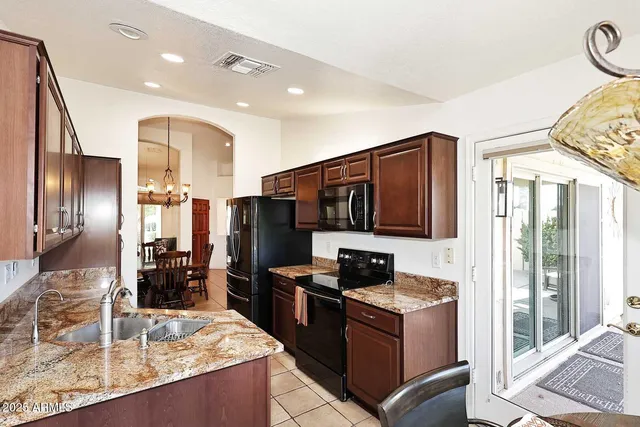 a kitchen with stainless steel appliances granite countertop a refrigerator and a stove top oven