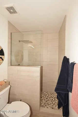 a bathroom with a toilet and a shower