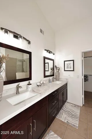 a bathroom with a double vanity sink and a mirror