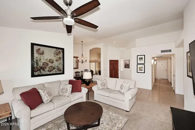 a living room with furniture and a ceiling fan