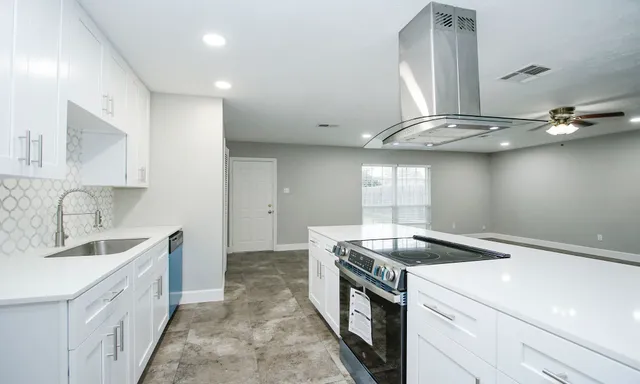 a kitchen with a sink a stove and cabinets