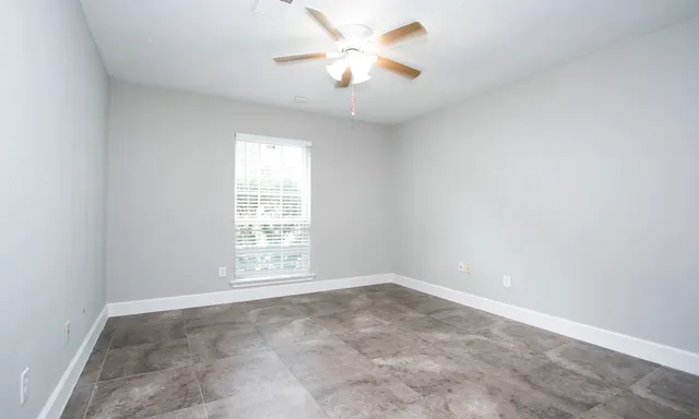 an empty room with closet and a chandelier fan