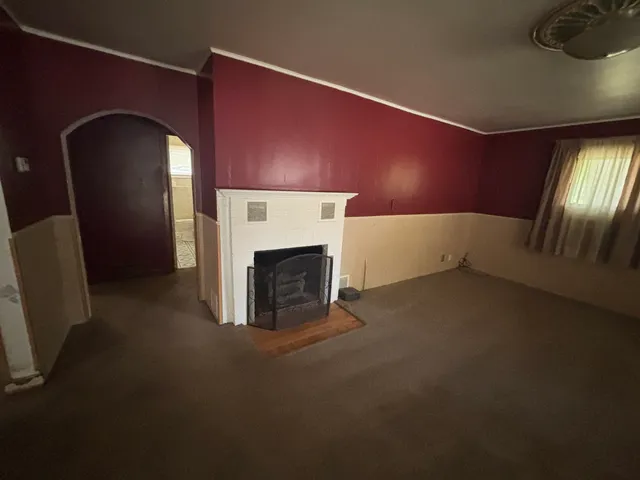 a view of empty room with fireplace and window