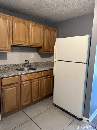 a white refrigerator freezer sitting inside of a kitchen