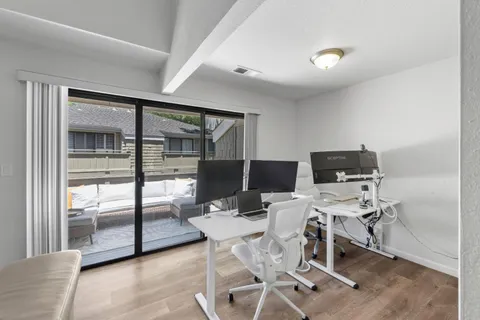 a view of a workspace with furniture and a window