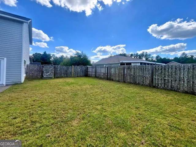 a view of a back yard of the house with a swimming pool