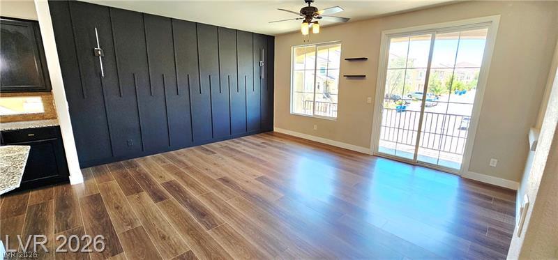 Natural light floods this room, highlighting the elegant hardwood floors and modern accent wall.
