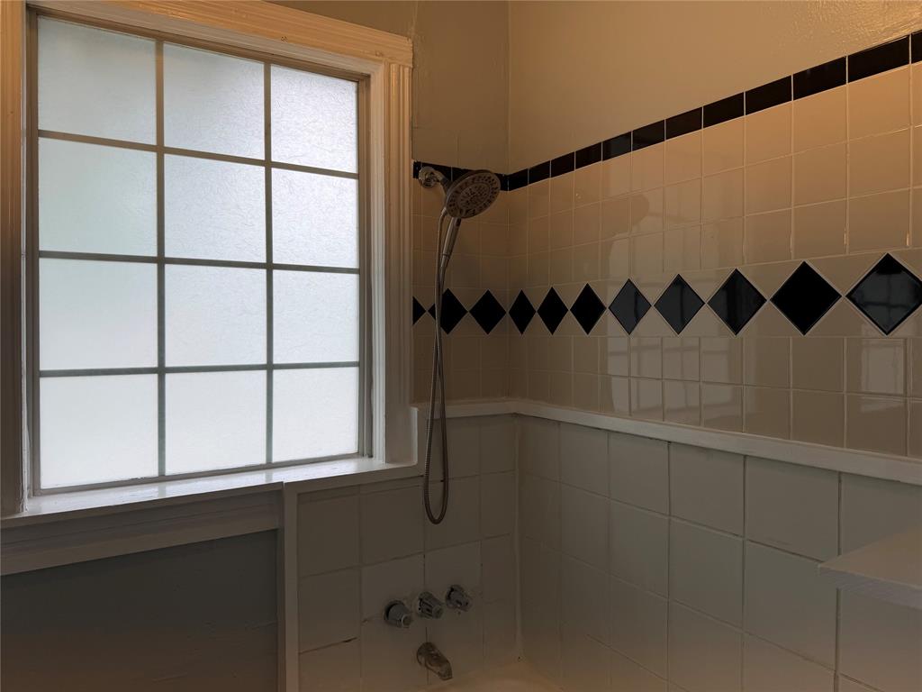 801 Wayne Street Dallas, TX 75223 - Photo 7 of 15 a bathroom with a shower and a window