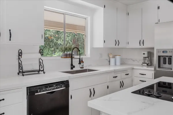 a kitchen with granite countertop white cabinets and white appliances