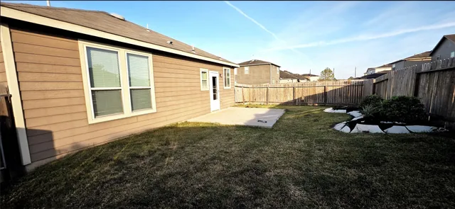 a view of a backyard with wooden fence
