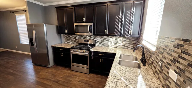 a kitchen with granite countertop a stove and a refrigerator