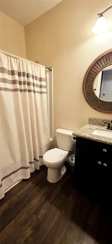 a bathroom with a granite countertop bathtub sink and toilet