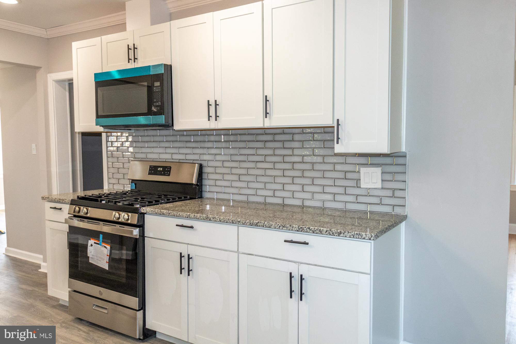 26 Byron Avenue Hamilton, NJ 08610 - Photo 11 of 33 a kitchen with granite countertop a stove top oven microwave and cabinets