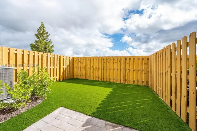 a view of yard with swimming pool and wooden fence