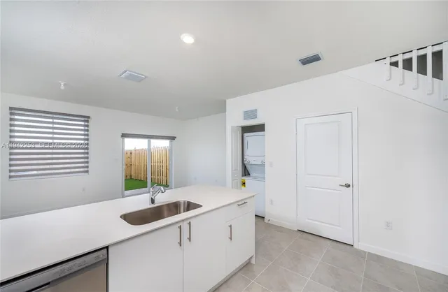 a view of kitchen with refrigerator and a fireplace