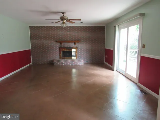 an empty room with windows and fireplace