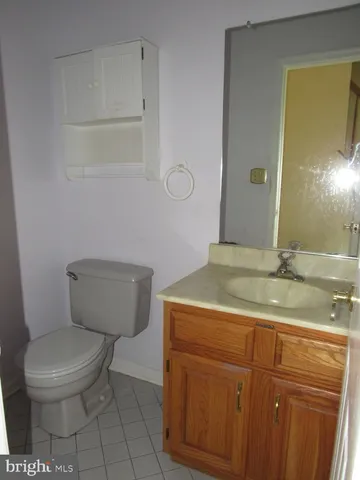 a bathroom with a granite countertop toilet sink and mirror
