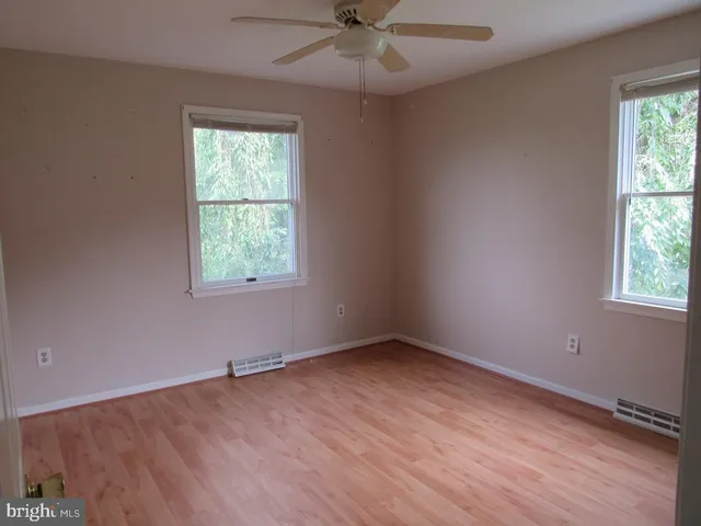 an empty room with a window and a ceiling fan