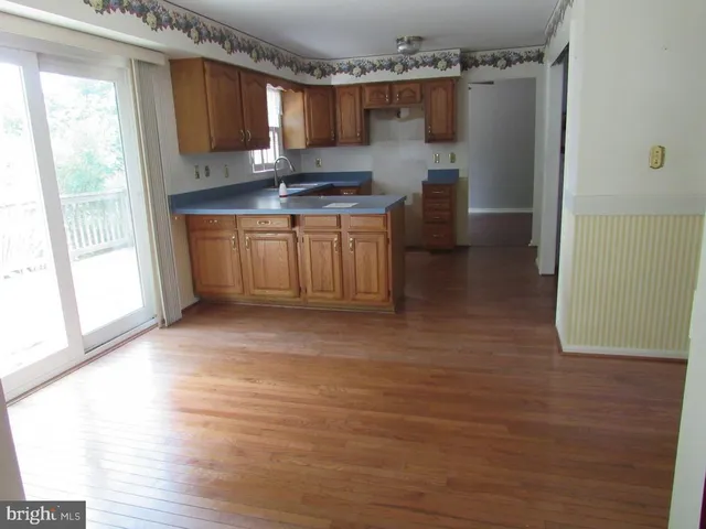 a kitchen with stainless steel appliances a sink cabinets and wooden floor