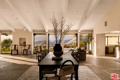 a view of a workspace with furniture and floor to ceiling window