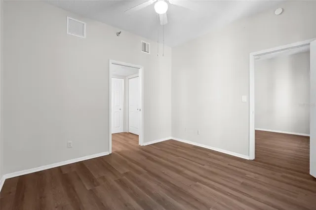 a view of an empty room with wooden floor