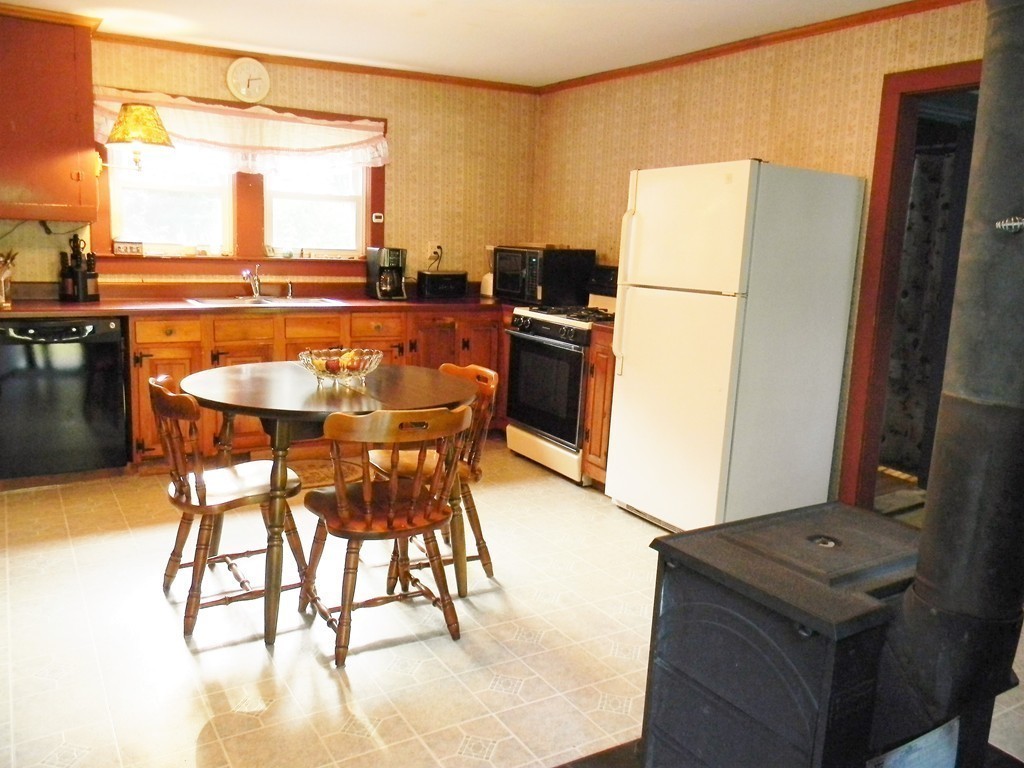 18 Flat Rock Road Petersham, MA 01366 - Photo 14 of 26 a kitchen with stainless steel appliances kitchen island a table and chairs in it