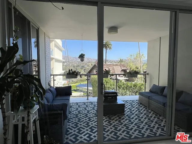 a living room with furniture floor to ceiling window and a table