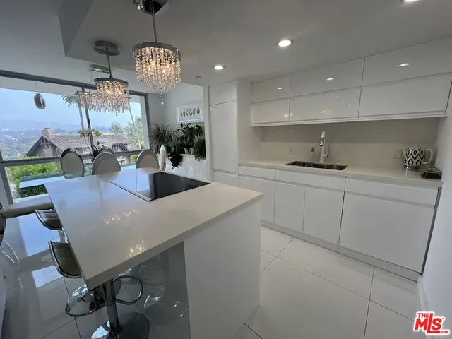 a kitchen with a table chairs and white cabinets