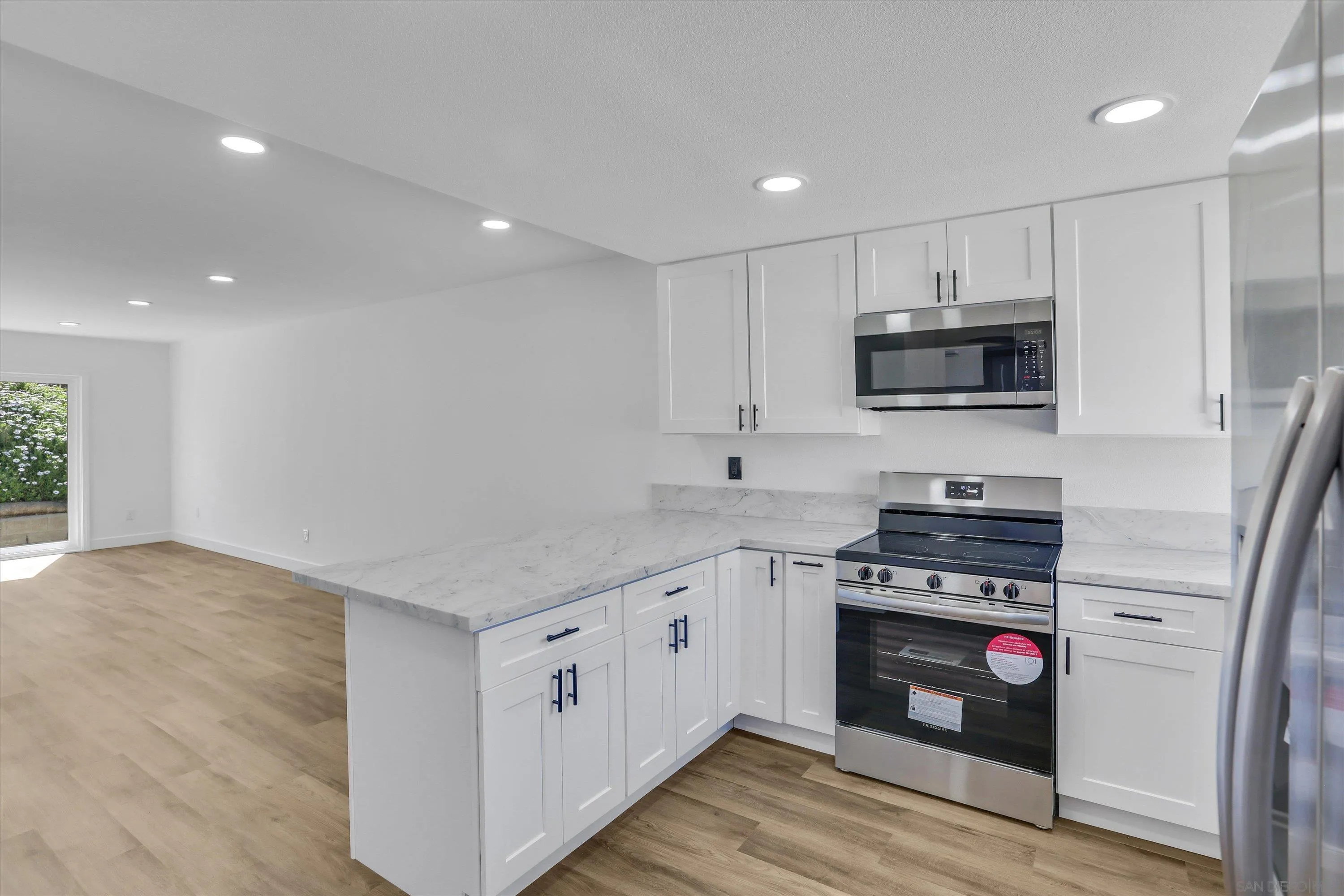 a kitchen with stainless steel appliances a stove sink microwave and cabinets