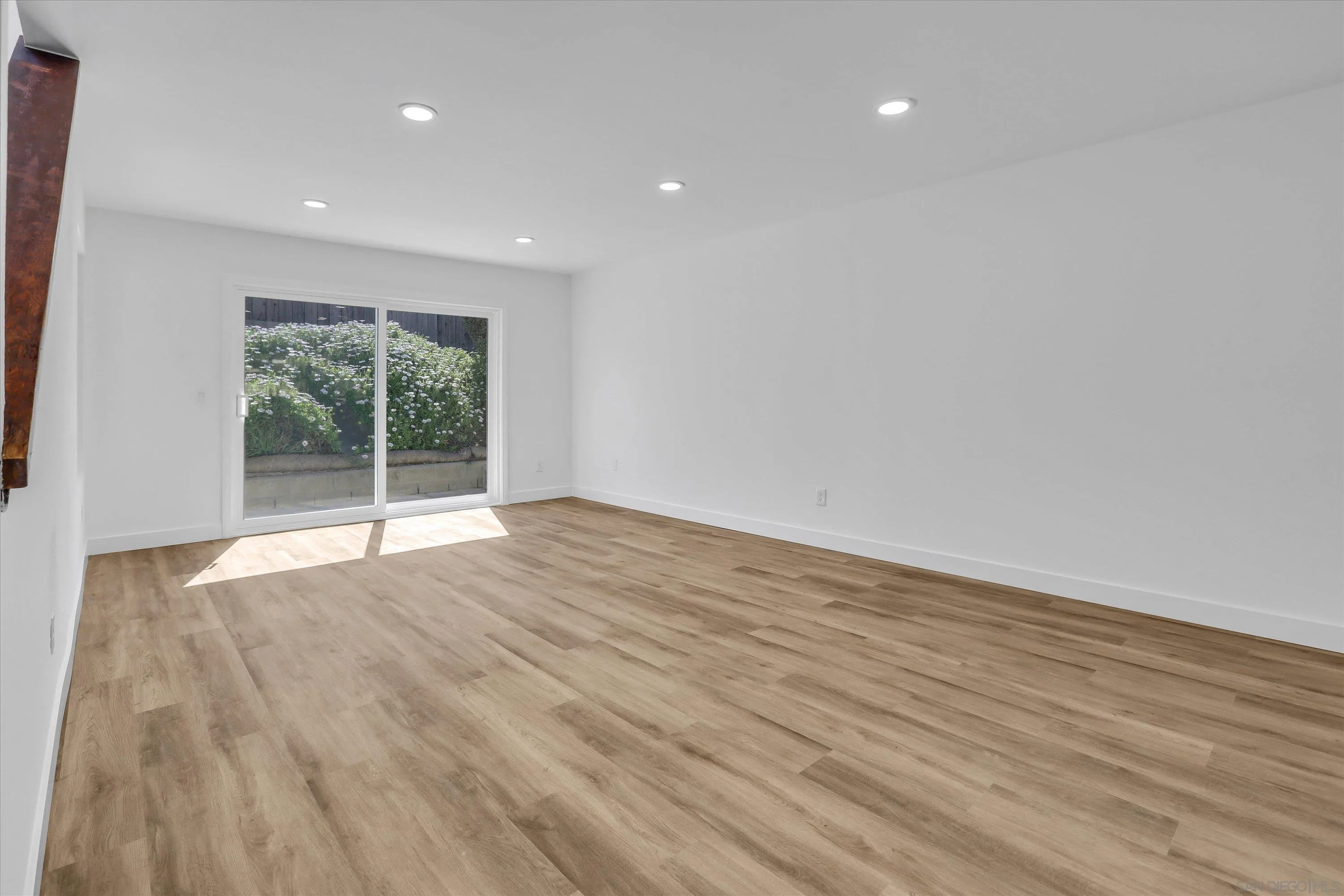 75 3rd Avenue, Unit 22 Chula Vista, CA 91910 - Photo 8 of 23 a view of an empty room with wooden floor and a window
