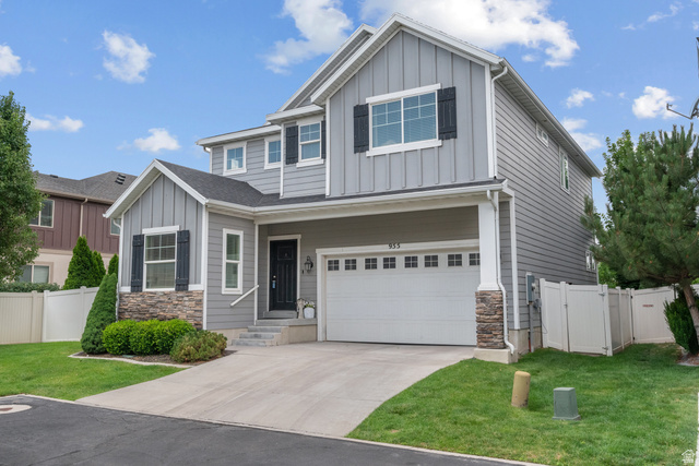 955 Delorean Lane Midvale, UT 84047 - Photo 1 of 47 Contemporary residence featuring a two-car garage, stone accents, board and batten siding, horizontal siding, and a fenced yard