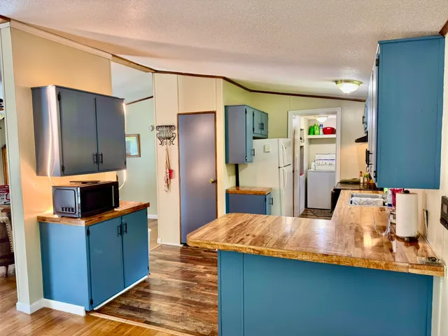 a kitchen with stainless steel appliances kitchen island granite countertop a refrigerator and a sink