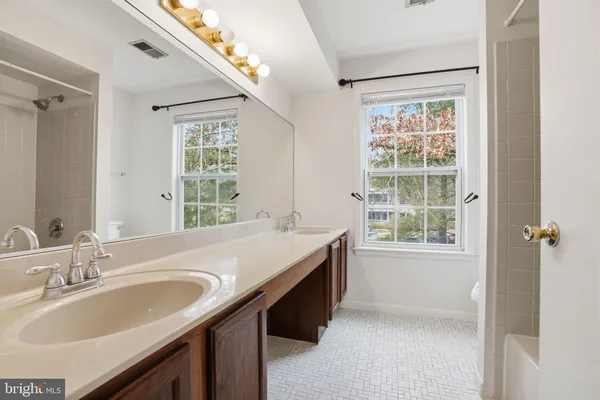 a bathroom with a granite countertop sink and a large mirror