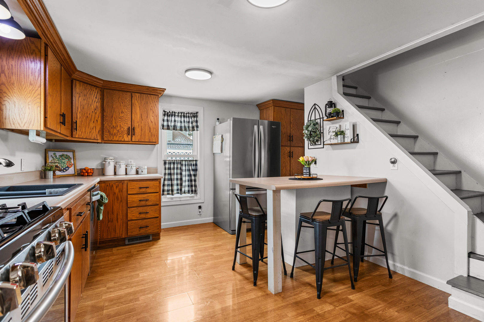 306 Shimp Road Milmine, IL 61855 - Photo 11 of 31 a kitchen with stainless steel appliances granite countertop a stove top oven a sink a dining table and chairs with wooden floor