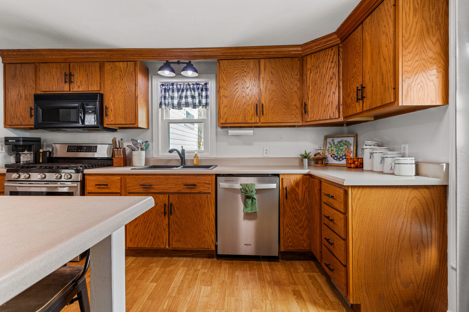 306 Shimp Road Milmine, IL 61855 - Photo 12 of 31 a kitchen with stainless steel appliances granite countertop wooden cabinets a sink and dishwasher a stove with wooden floor