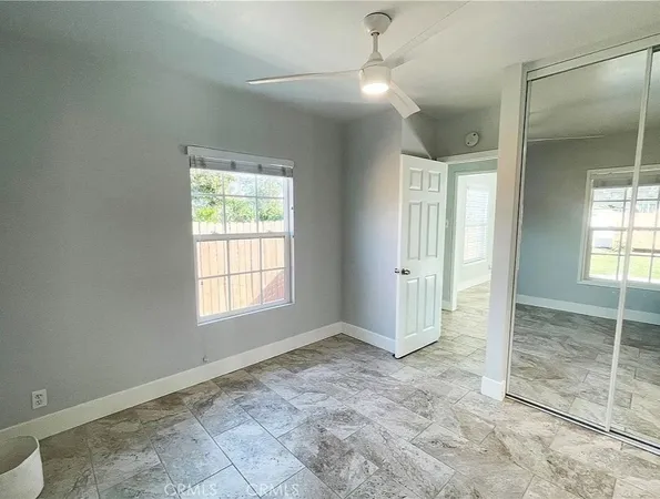 an empty room with closet and windows