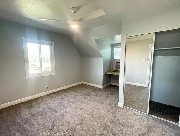 an empty room with closet and a window
