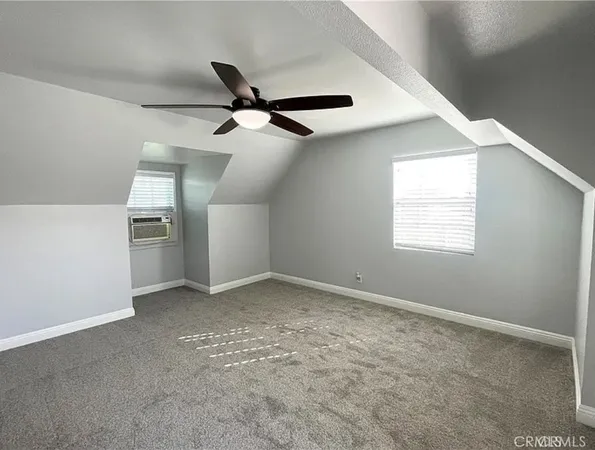 en empty room with windows and ceiling fan