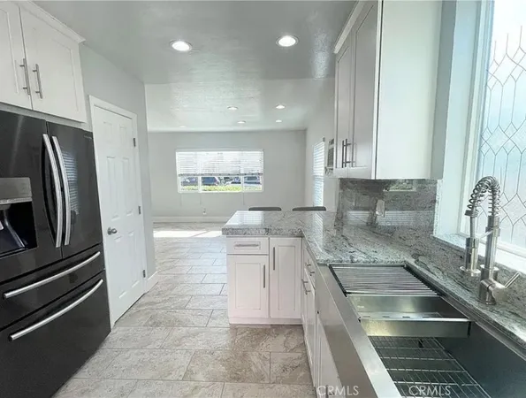 a kitchen with stainless steel appliances granite countertop a refrigerator and a stove