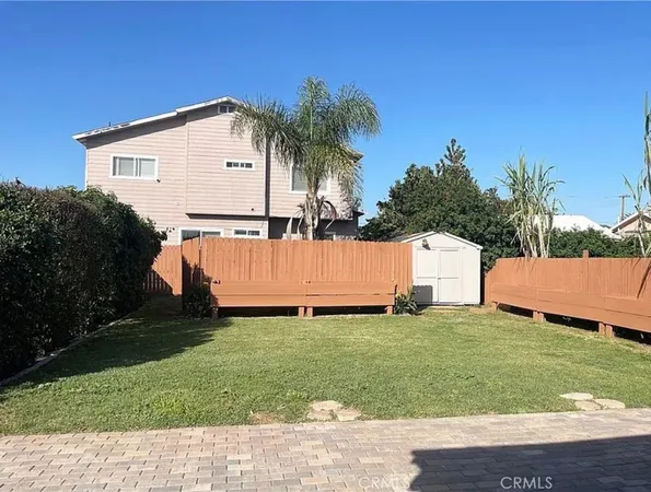 a view of a house with backyard and a tree