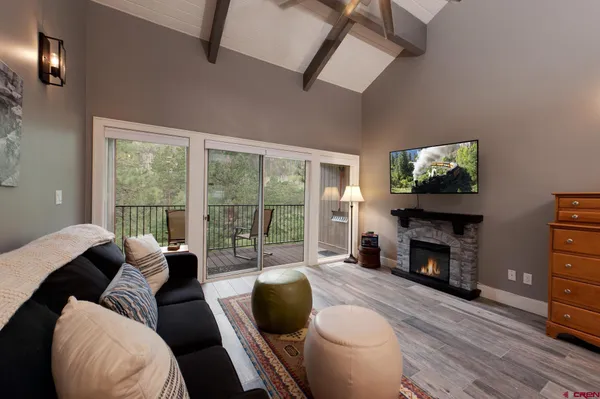 a living room with furniture a fireplace and a flat screen tv