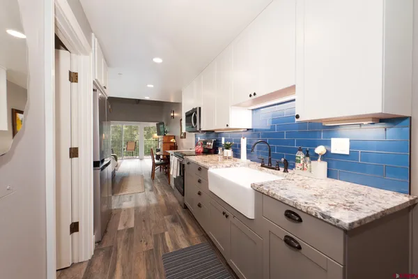 a open kitchen with granite countertop a sink dishwasher stove and refrigerator