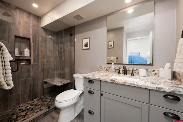 a bathroom with a sink toilet vanity and shower