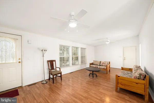 a living room with furniture and a large mirror next to a window