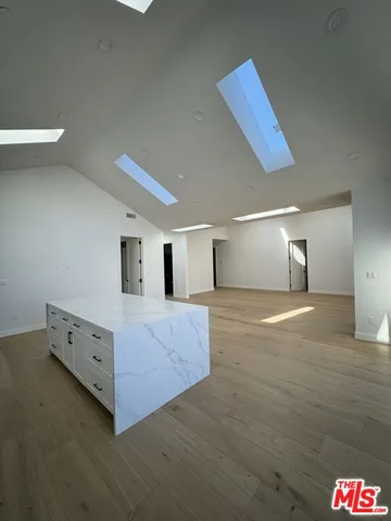 a spacious bedroom with a bed and a night stand