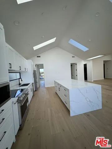a large kitchen with cabinets and stainless steel appliances
