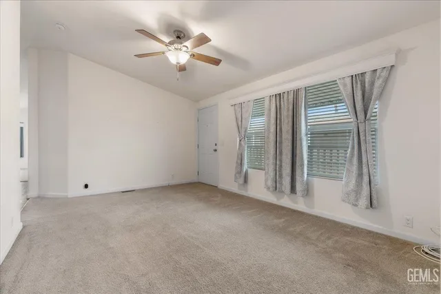 an empty room with closet and a ceiling fan
