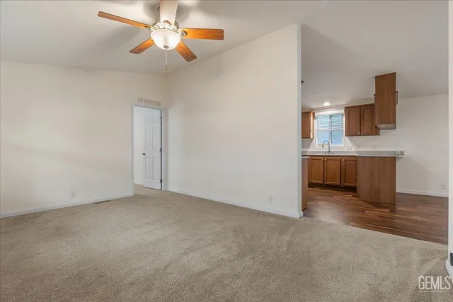 a view of a kitchen with a sink and a chandelier fan